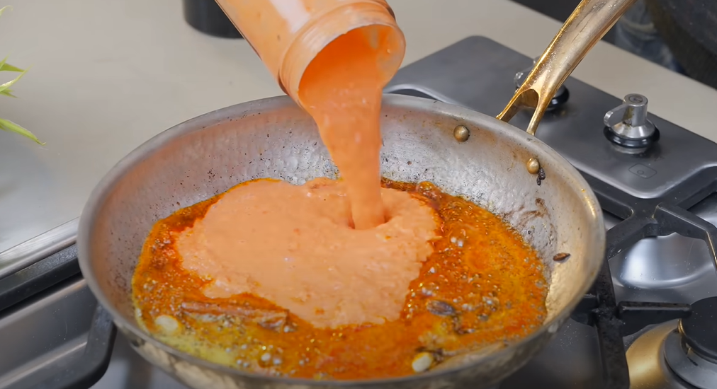 Tomato-onion masala base being cooked for paneer curry