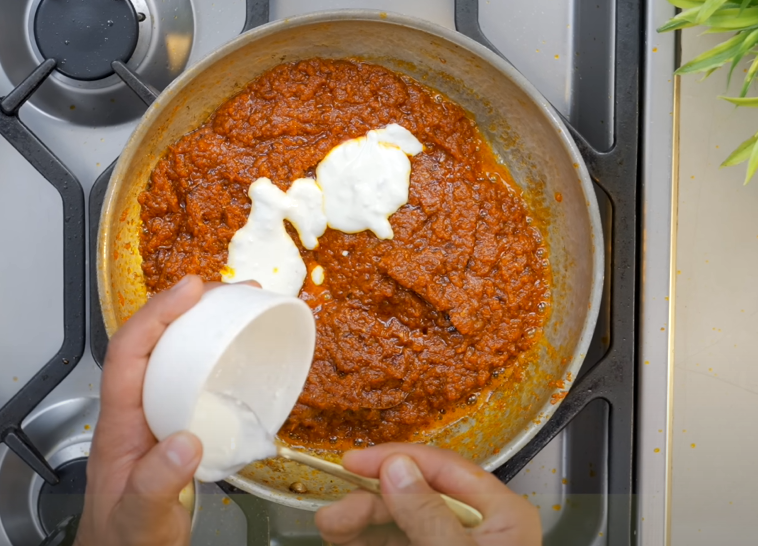Curd, garam masala, and coriander powder added to paneer gravy