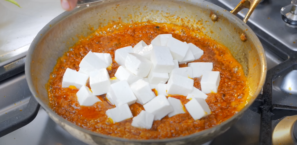 Soft paneer cubes added to spicy and creamy gravy