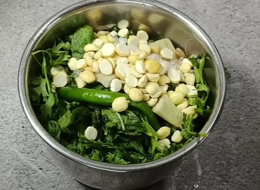 मिक्सी में धनिया, पुदीना, मसाले और ठंडा पानी डालकर तैयार की जा रही एकदम हरी और ताज़ा हरी चटनी – देसी नाश्ते के लिए परफेक्ट