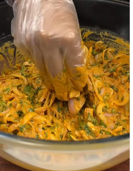 पकौड़ी के मिश्रण में थोड़ा-थोड़ा पानी डालकर उसे अच्छे से मिलाते हुए लटपटा बैटर तैयार किया जा रहा है।
