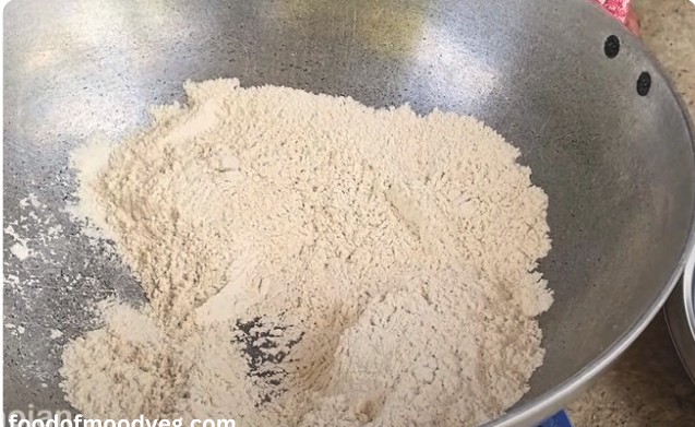 कड़ाही में बिना घी के गेहूं का आटा मध्यम आंच पर भूनते हुए