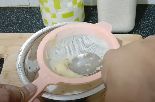छलनी में मौसमी का जूस छानते हुए, ताकि बीज और रेशा अलग हो जाए