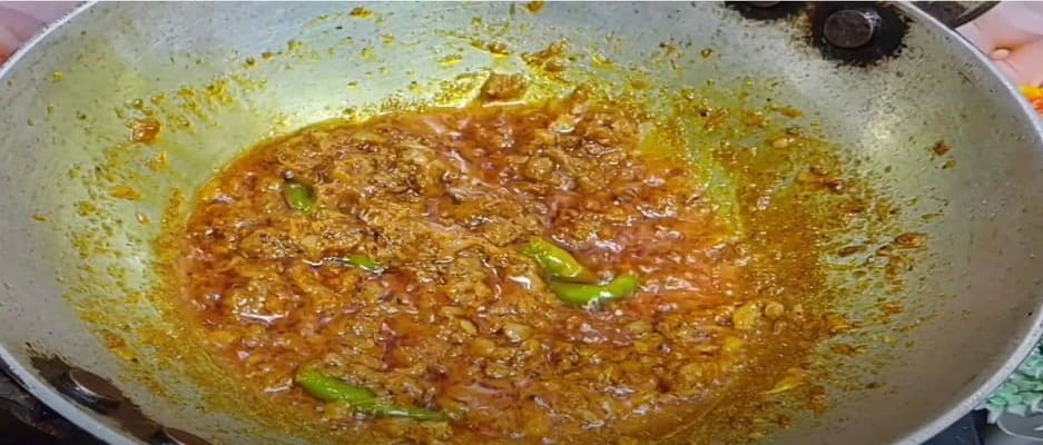 आलू कचोरी के मसाले में अदरक-लहसुन पेस्ट, हरी मिर्च और सूखे मसाले डालकर भूनते हुए