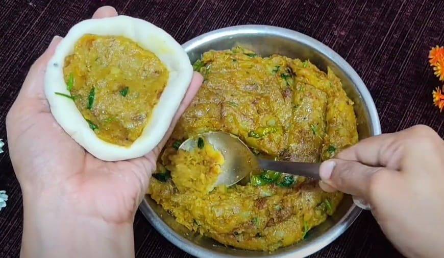 आलू मैदा की कचोरी भरते हुए – लोई में स्टफिंग डालकर अच्छे से बंद करते समय का स्टेप