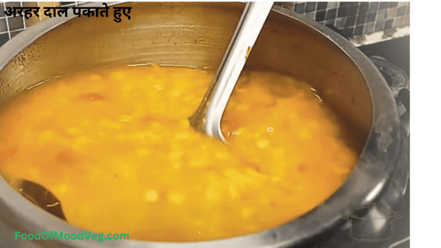 अरहर दाल में पानी डालकर कुकर में पकाते हुए 3-4 सीटी तक