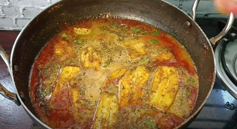 कच्चे केले को तैयार मसालेदार ग्रेवी में डालकर धीमी आँच पर पकाते हुए