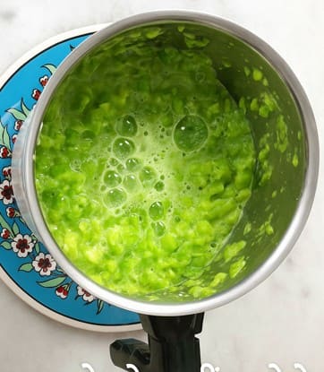 मिक्सर में हरे मटर को थोड़ा पानी डालकर दरदरा पीसते हुए पेस्ट तैयार किया गया